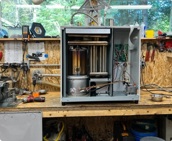 A Toyo and Rennai Heater sitting on a workbench, being repaired.